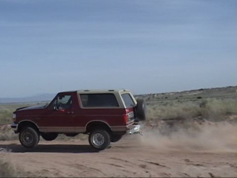 1994 Ford Bronco - This 1994 Ford Bronco is seen driving on a dirt road, creating a cloud of dust behind it.