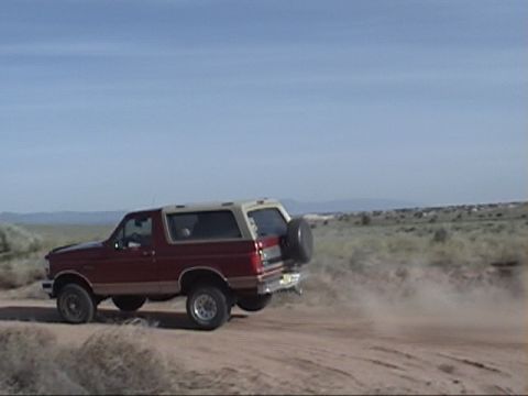 1994 Ford Bronco - This 1994 Ford Bronco is kicking up dust as it drives on a dirt road.