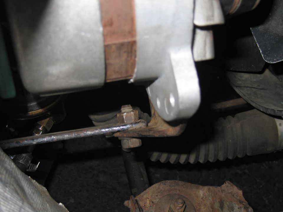 Close-up of an alternator bracket and adjustment arm in an engine bay
