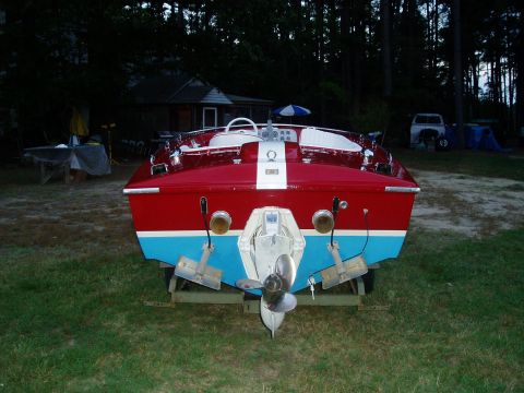 1978 Ford F-250 - Rear view of a red and blue boat on a trailer, with outdrives and propeller clearly visible.
