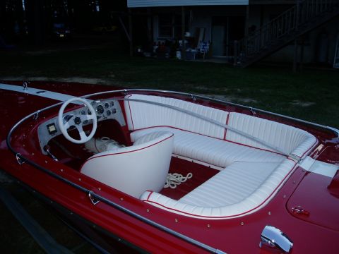 1978 Ford F-250 - Interior view of a classic red speed boat white upholstered seating and a white steering wheel.