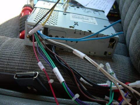 1988 Ford Bronco - Close-up of a car stereo's wiring harness, showing various colored wires and labels.