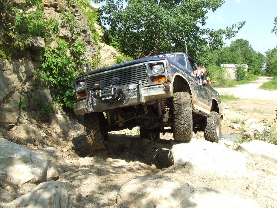 Black off-road SUV climbing rocks, front winch visible