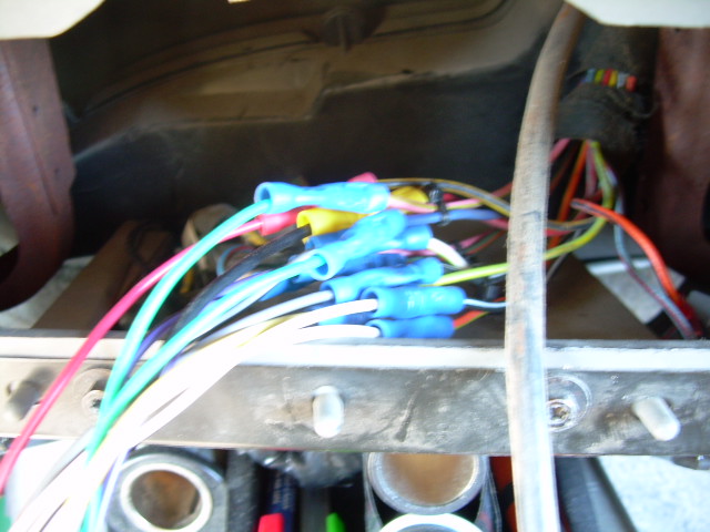 Bundle of colorful wires with blue crimp connectors, part of a vehicle's wiring harness