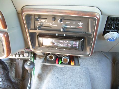 1988 Ford Bronco - The dashboard features wood trim, climate controls, and an aftermarket radio with a digital display.