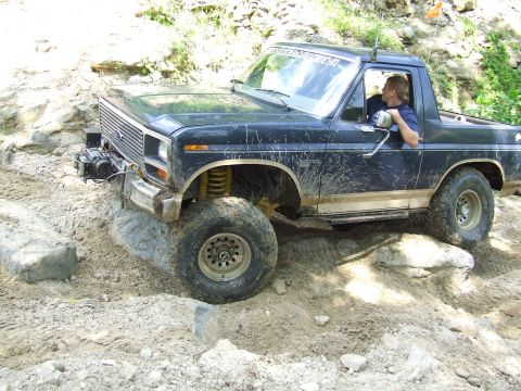 1986 Ford Bronco - This Ford Bronco is navigating a rocky, off-road trail with a driver behind the wheel.