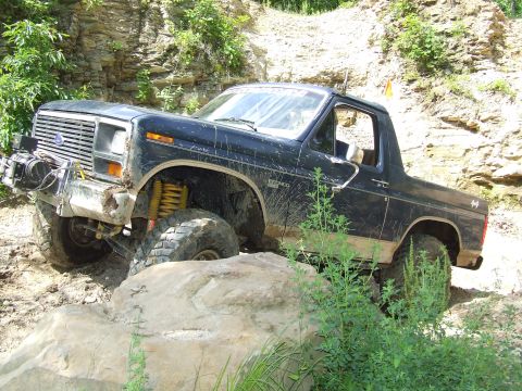1986 Ford Bronco - This Ford Bronco is navigating a rocky off-road course, showing its capabilities.
