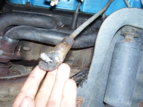 1996 Ford Bronco - Close-up of a damaged spark plug wire and surrounding engine parts.