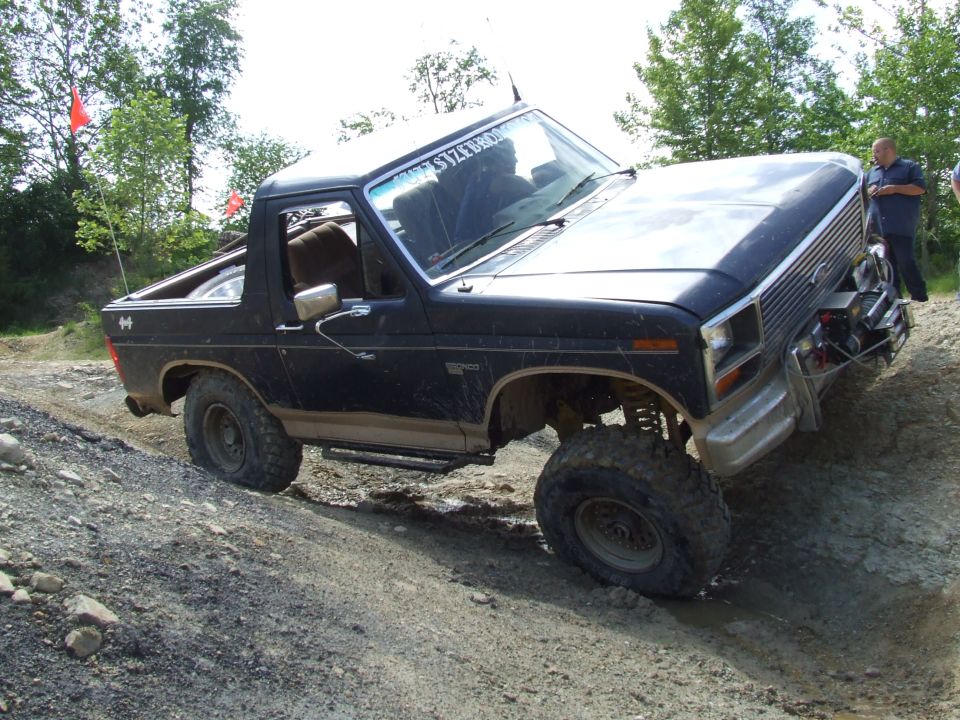 Black Ford Bronco with lifted suspension and off-road tires navigating a dirt trail