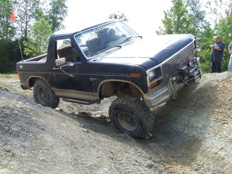 1986 Ford Bronco - This 1986 Ford Bronco tackles a challenging off-road course, demonstrating its capabilities.