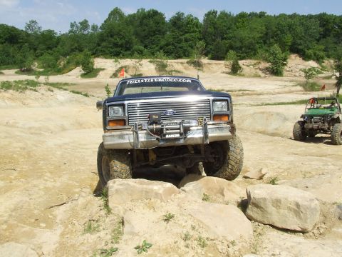 1986 Ford Bronco - Ford Bronco navigating rocky terrain with another off-road vehicle nearby.
