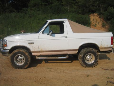 1996 Ford Bronco - This 1996 Ford Bronco features a tan soft top and is seen from the side.