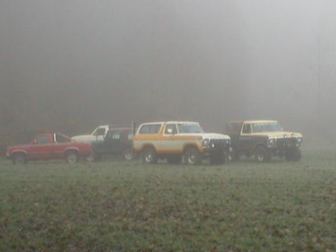 1978 Ford Bronco - A 1978 Ford Bronco is parked with three other SUVs in a foggy field.