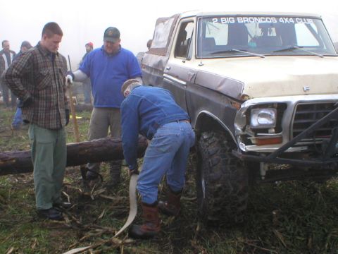 1978 Ford Bronco - A group of men are working to move a large log near a Ford Bronco, possibly for an off-road event.