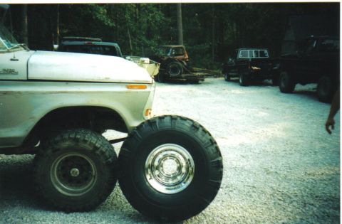 1979 Ford F-250 - A silver 1973 Ford F-Series truck is shown with large tires, and other trucks are visible in the background.