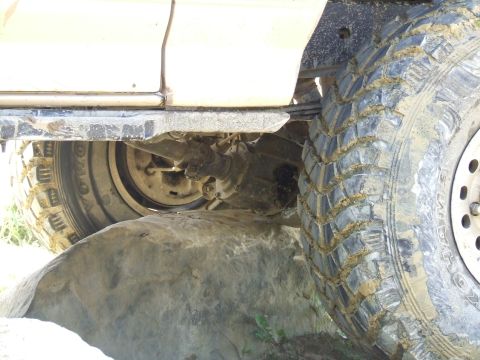1986 Ford Bronco - The vehicle's undercarriage and large tires are shown as it navigates rough terrain.
