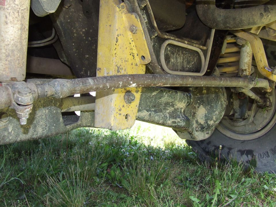 Undercarriage of a vehicle with yellow painted components and visible suspension parts