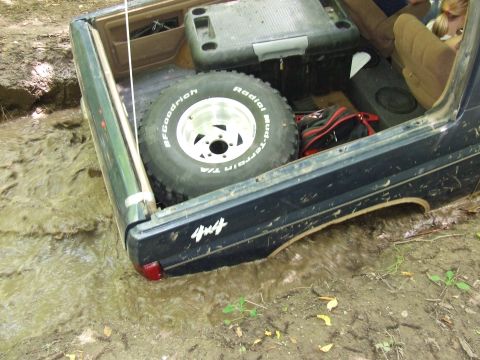 1986 Ford Bronco - This Ford Bronco is stuck in mud, with its spare tire and interior visible.