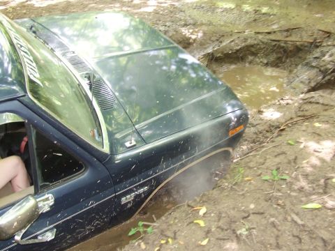 1986 Ford Bronco - This 1986 Ford Bronco is stuck in a muddy ditch, showing its front 3/4 view.
