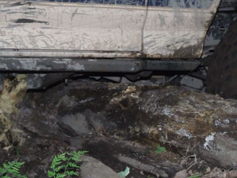 1986 Ford Bronco - This vehicle is stuck on rough terrain, with its side panel and tire visible above the ground.