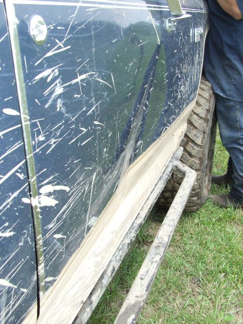 1986 Ford Bronco - This 1986 Ford Bronco shows signs of off-road use with extensive mud splatters and scratches on its dark blue paint.