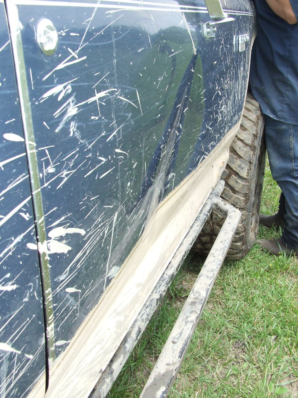 Side view of a mud-splattered 1986 Ford Bronco with running boards