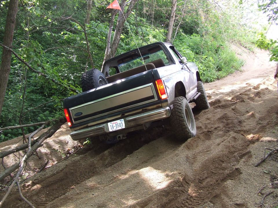 Rear view of a 1986 Ford Bronco climbing a dirt hill