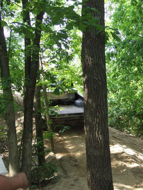 1986 Ford Bronco - Truck driving off-road on a dirt path, showing the rear of the vehicle and its bed.