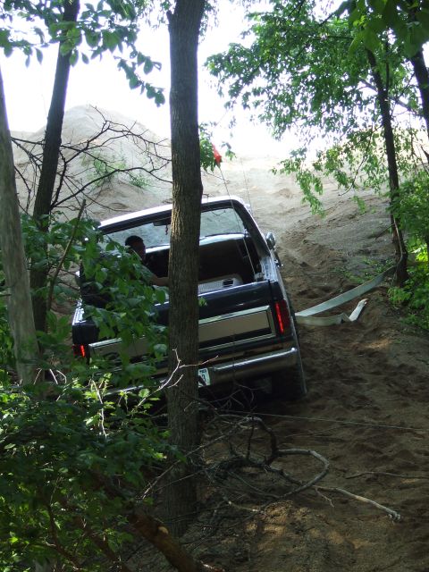 1986 Ford Bronco - Ford Bronco navigating a challenging off-road terrain on a sandy incline.