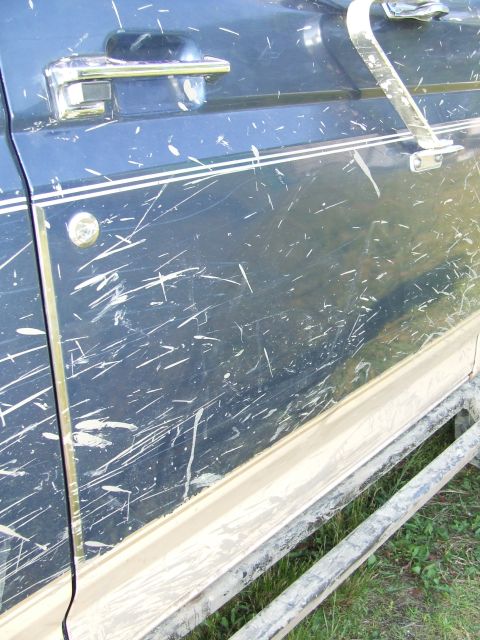 1986 Ford Bronco - This 1986 Ford Bronco's side door shows extensive damage from off-road use.