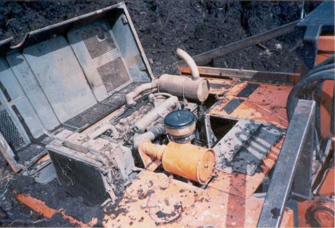 1990 Ford Bronco - The engine compartment of heavy machinery is shown with its hood open, revealing the engine and associated components.