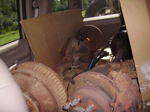 2000 Chevrolet Tahoe - Rear axle assemblies and brake drums are loaded inside a vehicle, obscuring the interior.