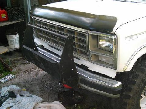 1986 Ford Bronco - The front end of a white Ford truck, likely from the early 1980s, is equipped with a heavy-duty bull bar.