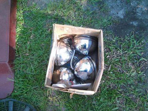 1986 Ford Bronco - A box of four chrome headlights sits on the grass.
