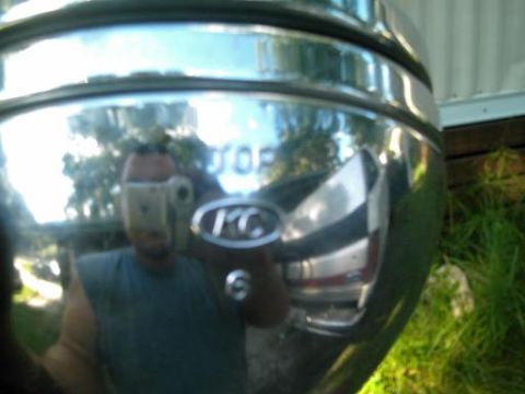 1986 Ford Bronco - Reflection in a chrome bumper shows a man taking a picture of himself and the surrounding environment.