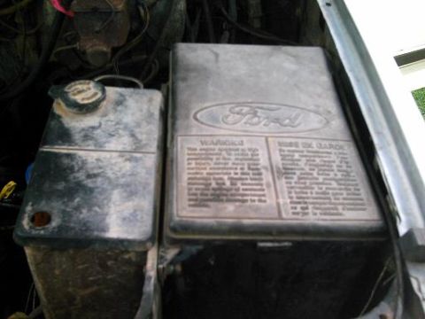 1986 Ford Bronco - Engine bay components including a Ford-branded cover and coolant reservoir are visible.