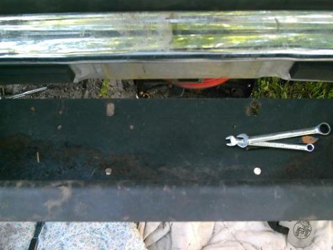 1986 Ford Bronco - Tools are laid out on a vehicle's bumper, suggesting some maintenance or repair work is underway.