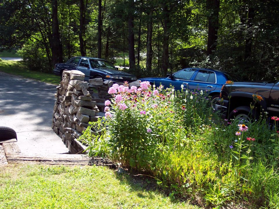 2001 Ford Crown Victoria side view parked near flowers and a stone wall
