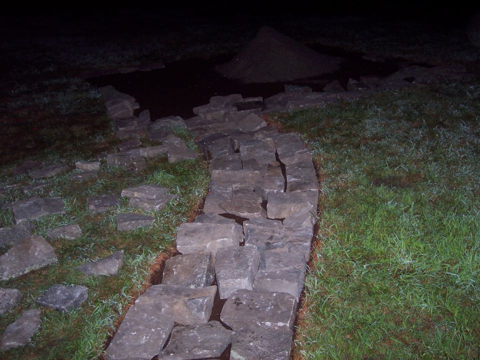 Stone wall construction in progress at night
