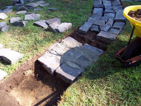 2001 Ford Crown Victoria - Construction of a flagstone path in progress, with materials and tools laid out on the grass.