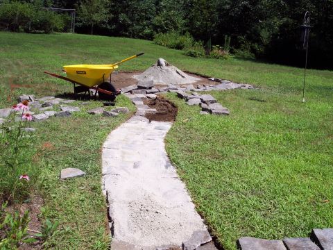 2001 Ford Crown Victoria - Construction of a stone garden path with a wheelbarrow and materials on a grassy lawn.