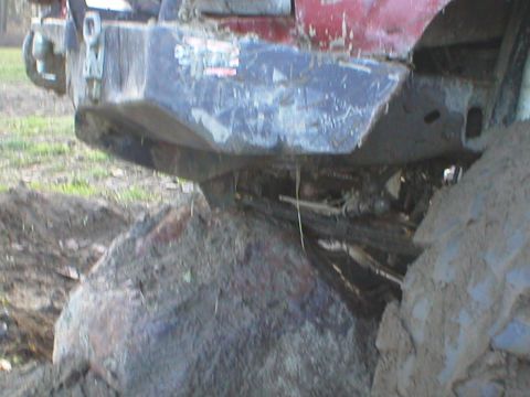 1978 Ford Bronco - This red vehicle appears to be stuck on a large rock, a prominent aftermarket bumper and winch system.