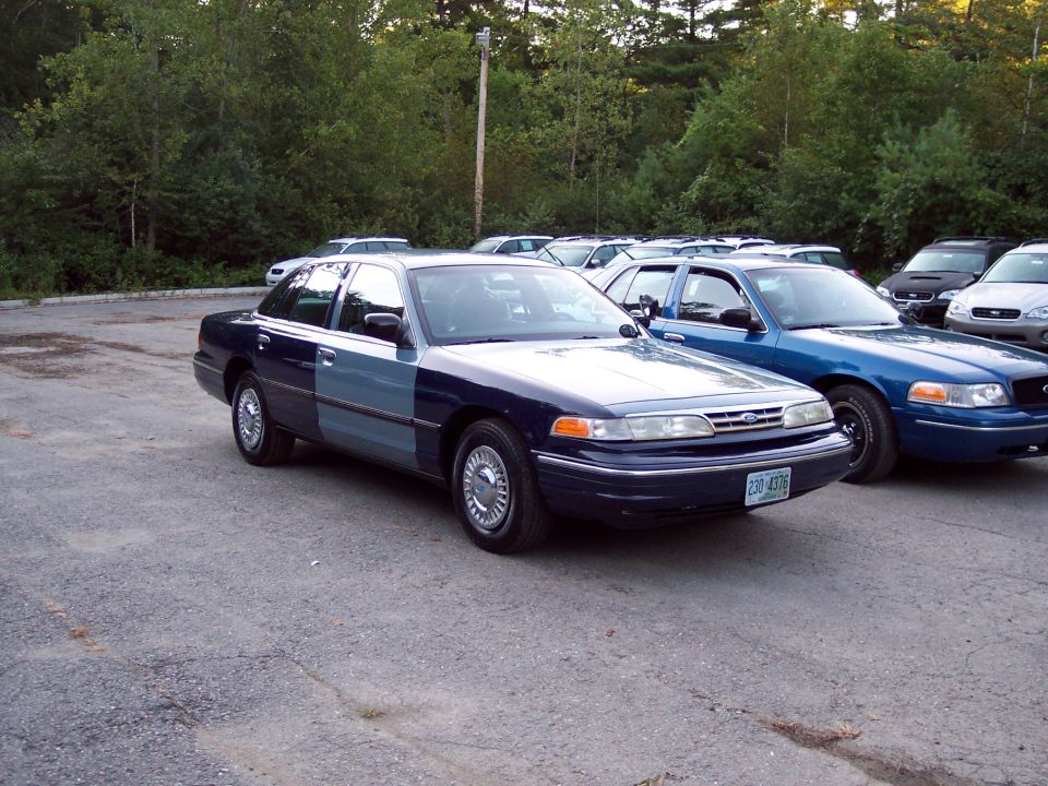 Two-tone Ford Crown Victoria parked next to a blue Ford Crown Victoria