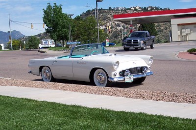 1972 Ford Ranchero - A white 1955 Ford Thunderbird convertible is parked near a gas station, with a pickup truck in the background.