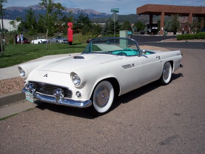 1972 Ford Ranchero - A white 1955 convertible with a turquoise interior and whitewall tires is parked on a street with mountains in the background.