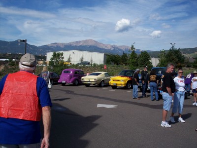 1972 Ford Ranchero - Several classic cars, including a 1972 Ford Ranchero, are gathered in a parking lot with people and mountains.