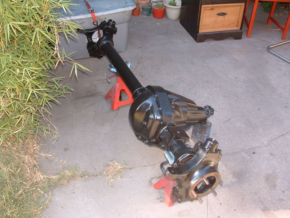Black Jeep Dana 35 rear axle assembly on red jack stands outdoors