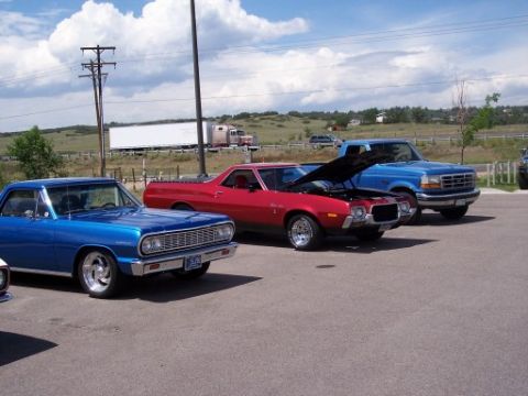 1972 Ford Ranchero - Three vehicles parked in a lot: a red 1970s Ford Ranchero, a blue 1960s Chevrolet Chevelle, and a blue Ford pickup truck.