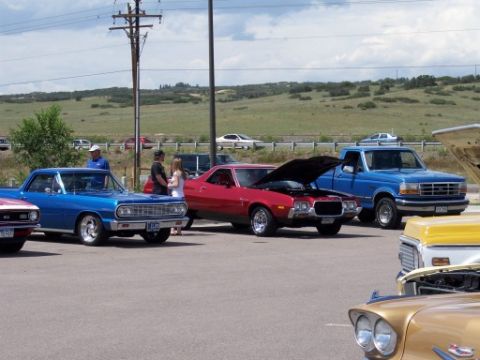 1972 Ford Ranchero - A red 1972 Ford Ranchero is parked with its hood up at an outdoor event.