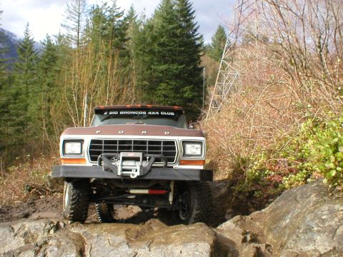 1978 Ford Bronco - 1978 Ford Bronco tackling a challenging off-road course with rocky obstacles.